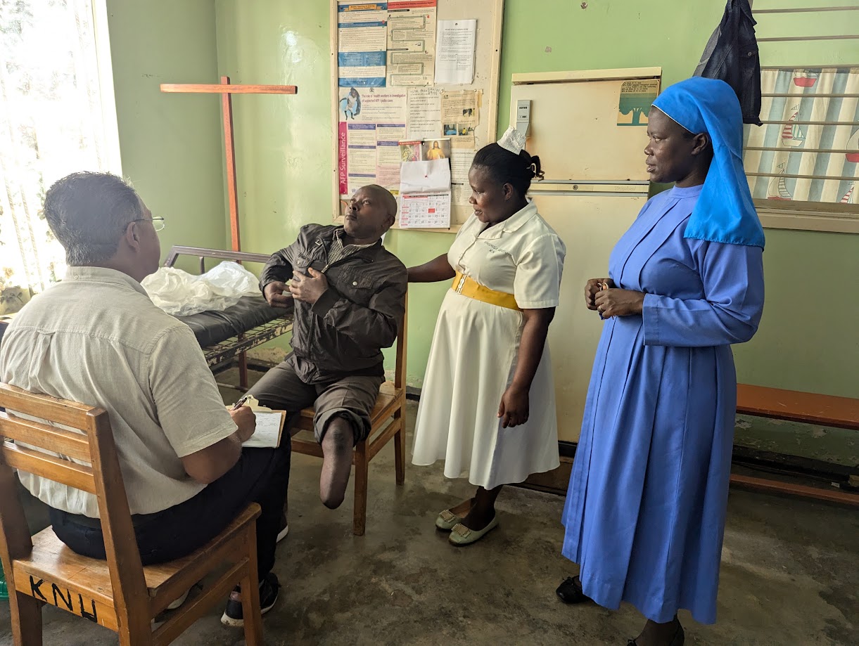 A patient consulting with medical and prosthetics team members during a mission in Uganda